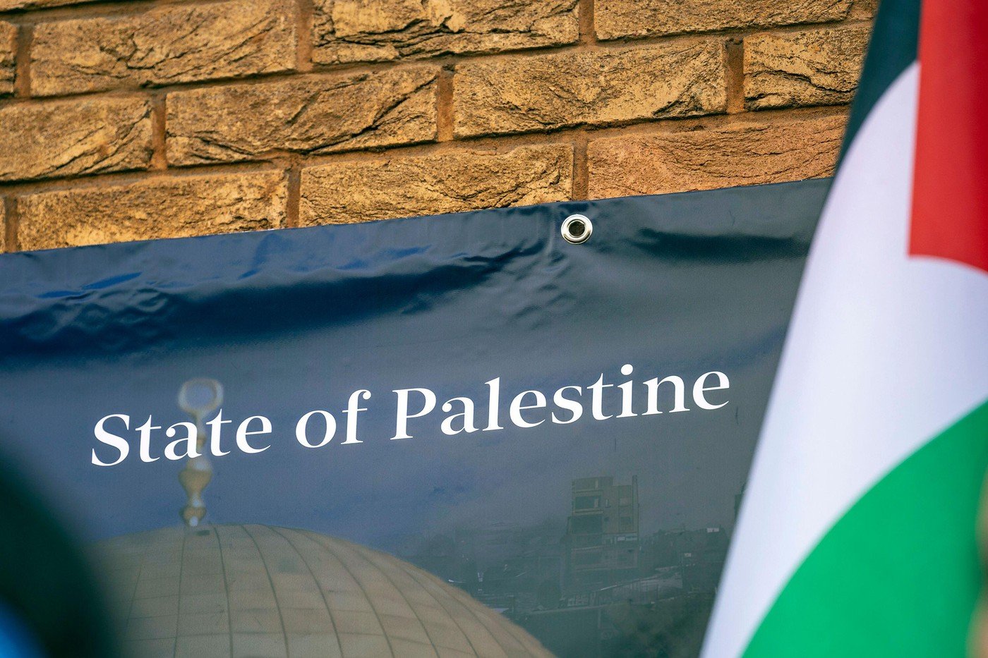 Odhalení palestinské vlajky na sídle palestinské mise v Londýně poté, co britská vláda oficiálně uznala Stát Palestina