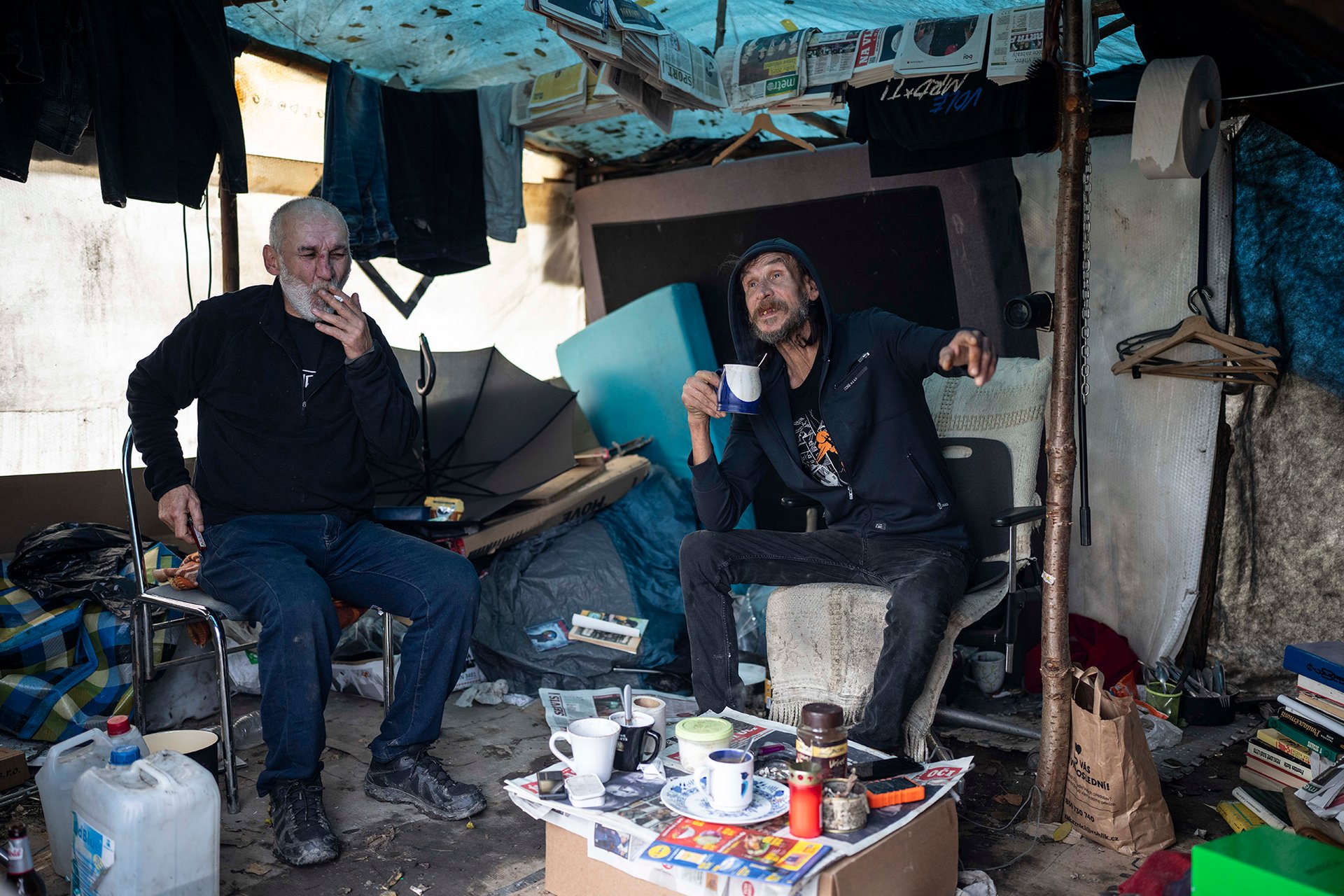 Československá dvojice Jura a Jiří ubytovnu nebo azylový dům odmítla a bydlí ve stanech postavených na okraji Karlína ve skrytu velké houštiny z náletových rostlin. Jídlo si berou z charity a nabíjejí si tam i powerbanky. Oba pracují – chodí pomáhat pořadatelům na fotbalové zápasy. „Současně jít ale do práce nemůžeme. Jeden tady vždycky musí hlídat,“ vysvětlují.