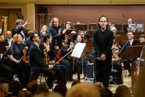 Koncertní sály a kluby jsou dnes potřeba víc než kdy jindy. (Bryce Dessner společně s Českou filharmonií při uvedení své skladby St. Carolyn by the Sea, únor 2026)