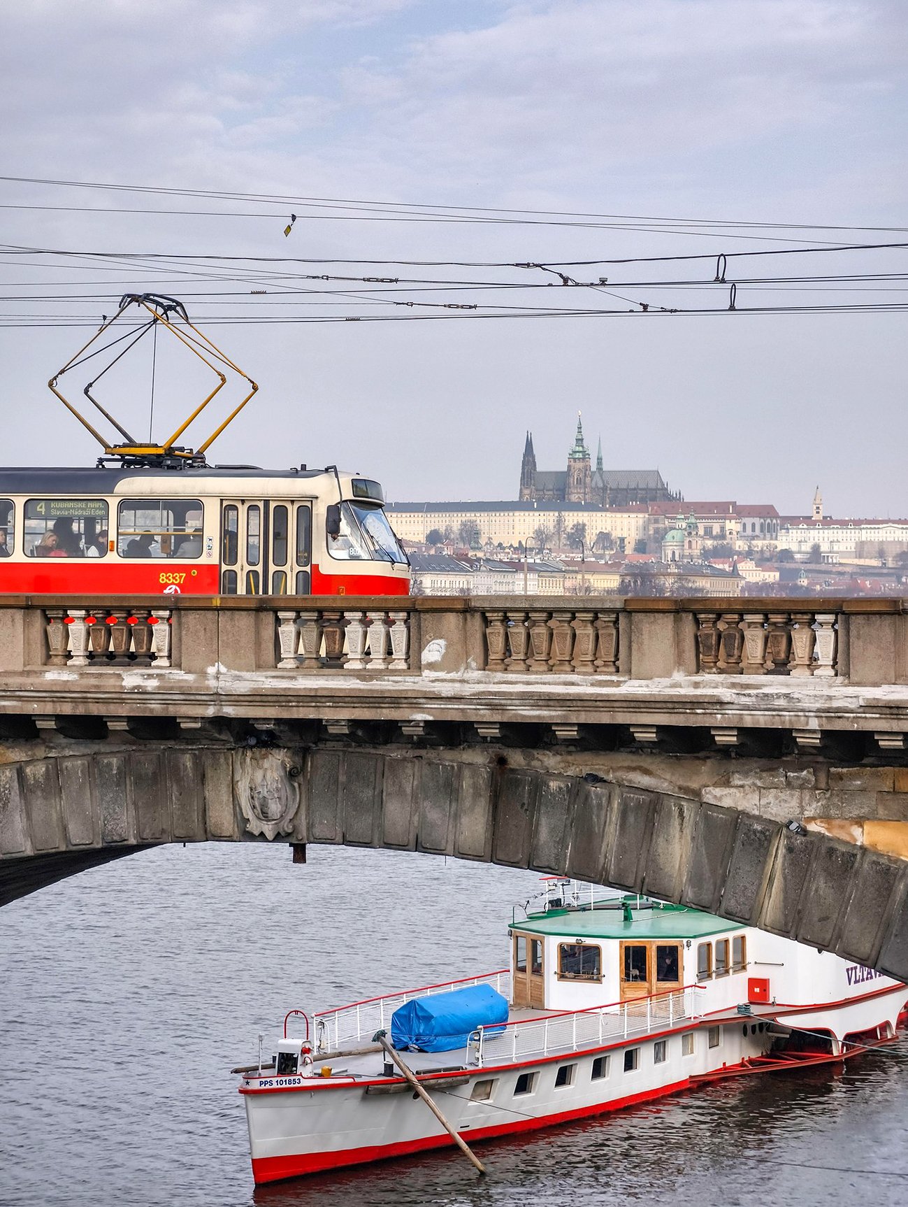 Prague, Czech Republic, March 11, 2026 – Urban daily life and transport. Public trams, passengers, and pedestrians crossing streets at crosswalks.