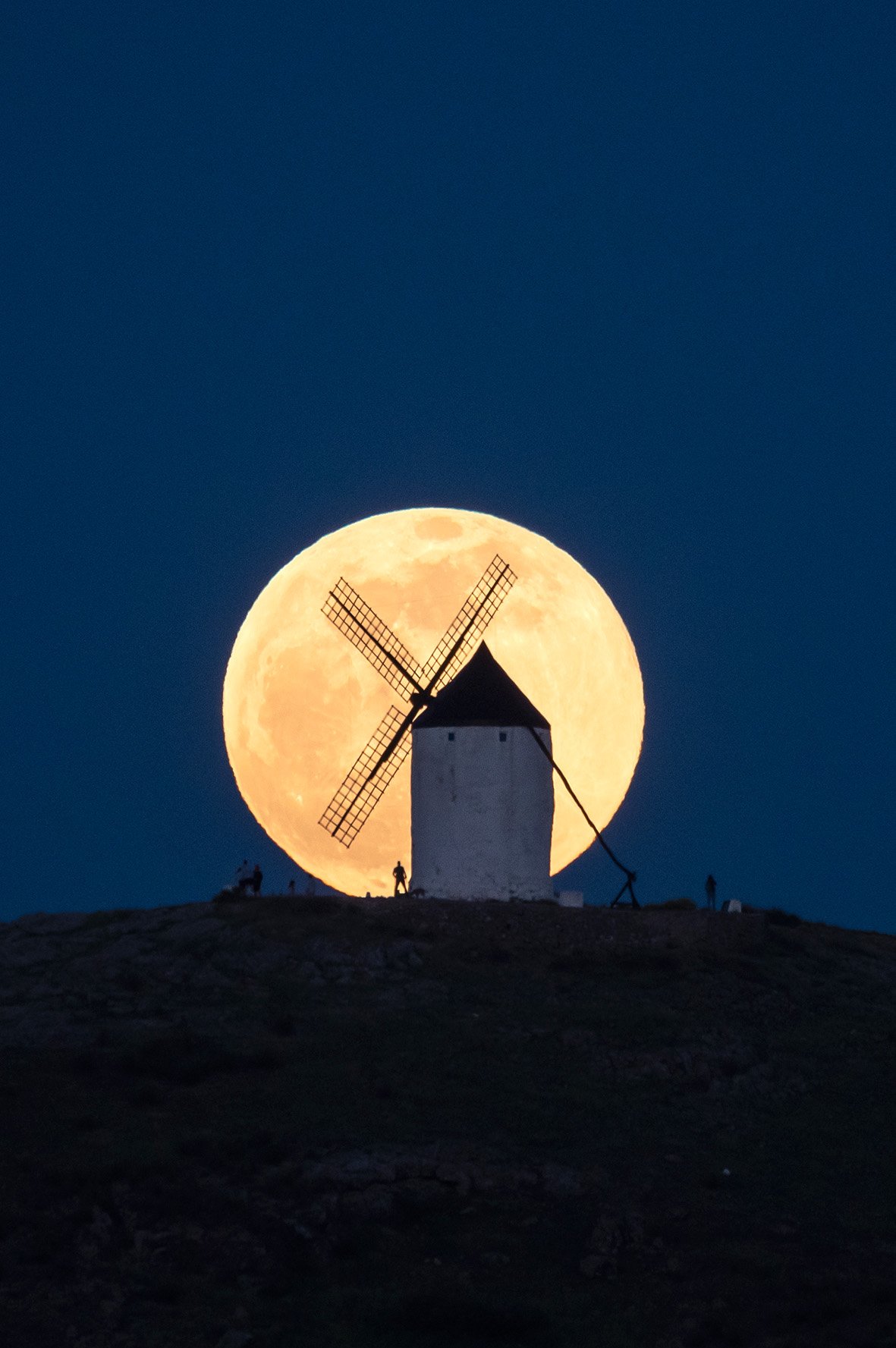 The full moon rises over a windmill in Consuegra, Toledo.