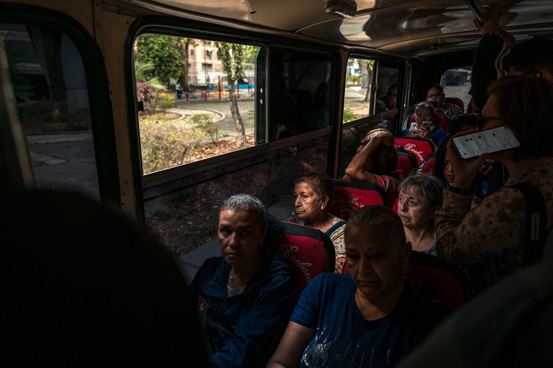 Lidé v přeplněném autobuse během dopravní špičky ve čtvrti Caricuao. Jednosměrná jízdenka stojí přibližně 0,15 USD, což je asi polovina celostátní hodinové minimální mzdy