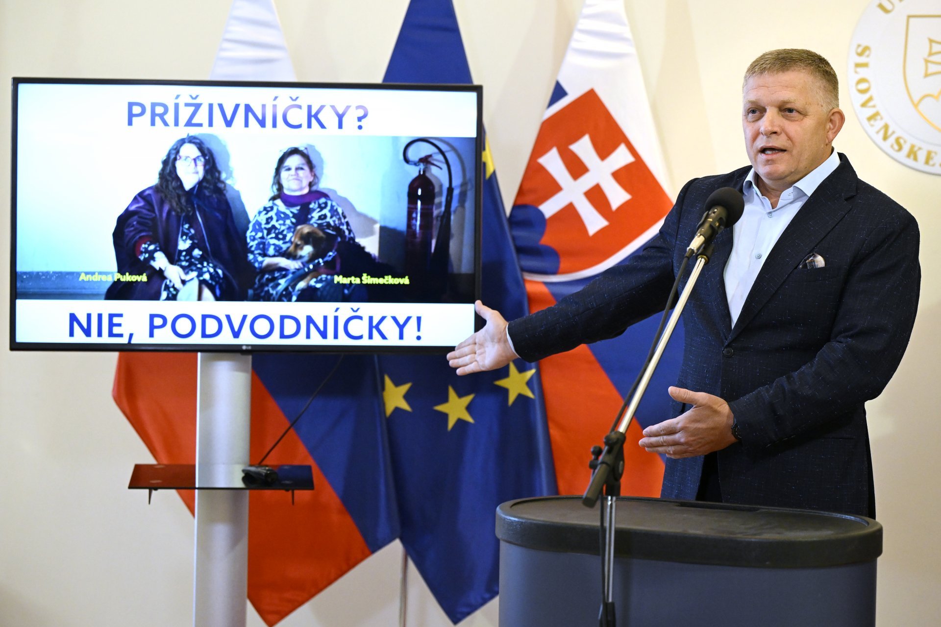 Premiér Fico na tiskovce v září 2025 před fotografií Marty Šimečkové a Andrey Pukové. 