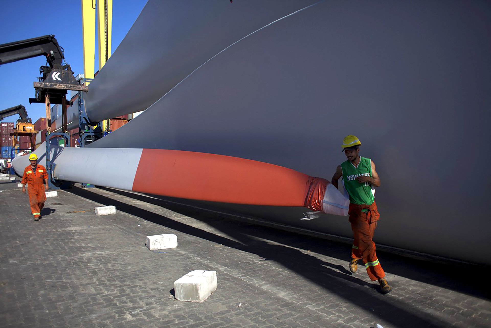 Dělníci v přístavu Montevideo vykládají vrtule větrných turbín.